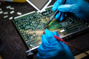 Are You Looking for Improved Vibration Resistance in Your Electronic Device? 2 A person in gloves Tests electronic equipment, Looking for Improved Vibration Resistance in an Electronic Device